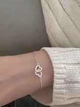 Armband mit ineinandergreifenden Herzanhängern